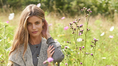 Woman in a summer flower field with Trollbeads necklaces, bracelets and earring