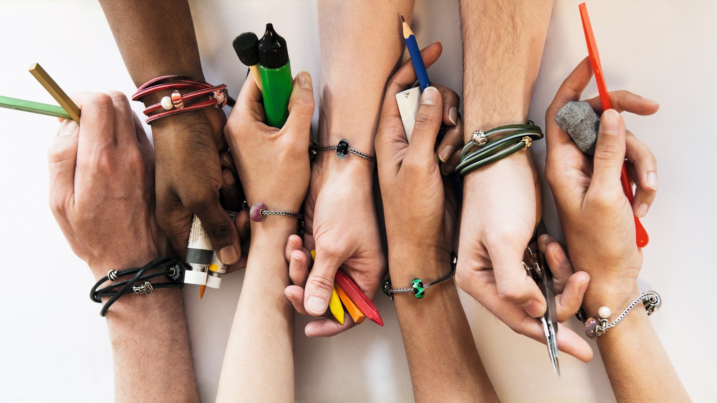 6 hands with every wrist containing a trollbeads bracelet and beads